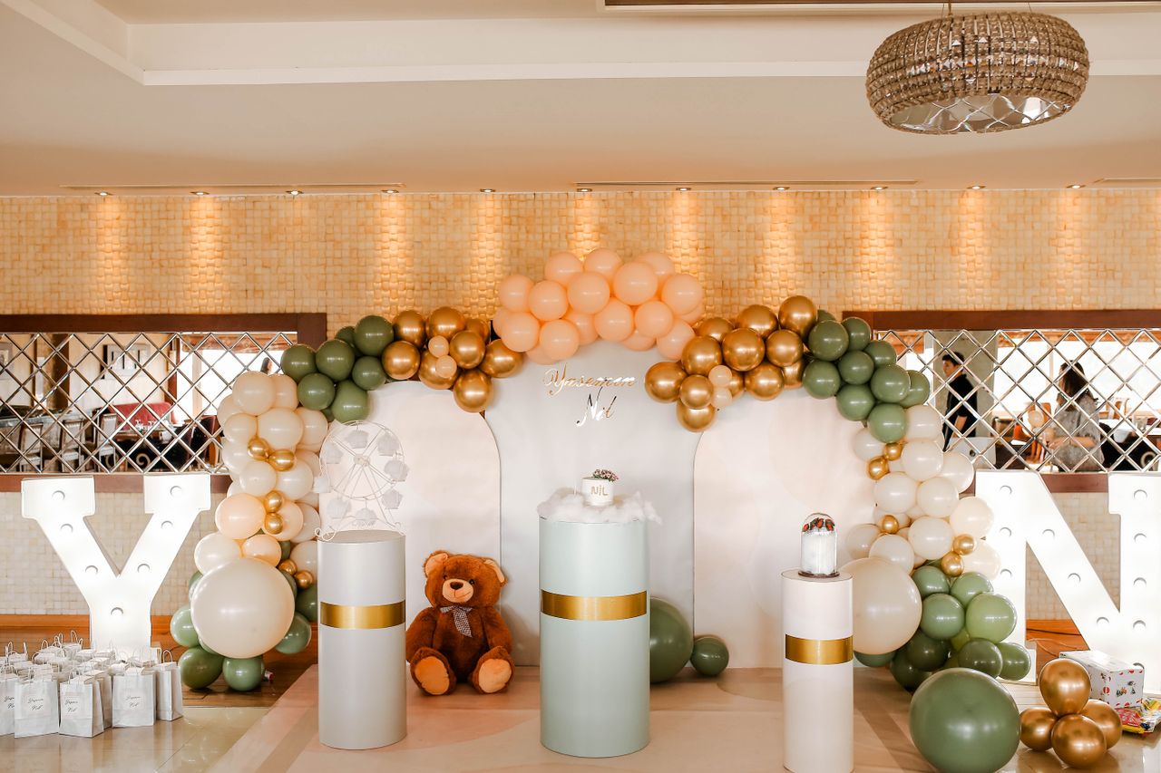 Stylish birthday decor featuring balloons and teddy bear in an elegant indoor setting.